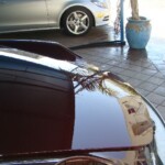 Before and after photographs of a damaged Porsche that was repaired by Elite Paint & Body Shop in West Palm Beach, Florida.